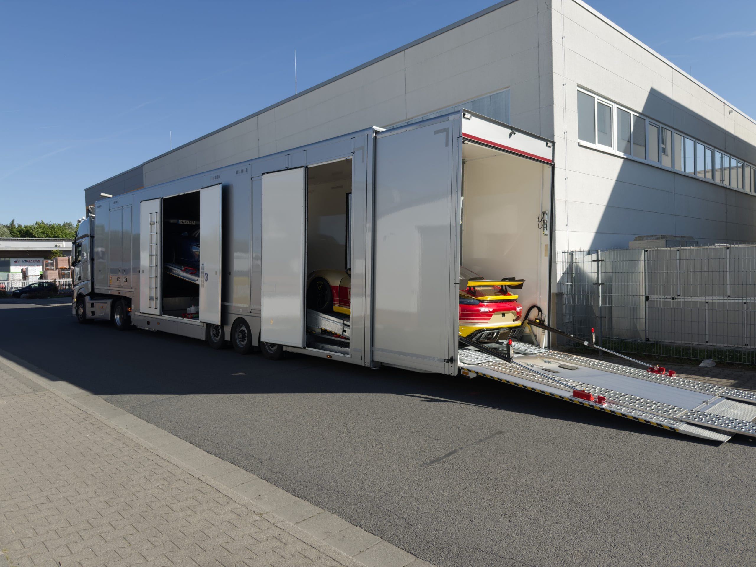 Geschlossener Fahrzeugtransporter mit mehreren Sportwagen bei WrapIndustries