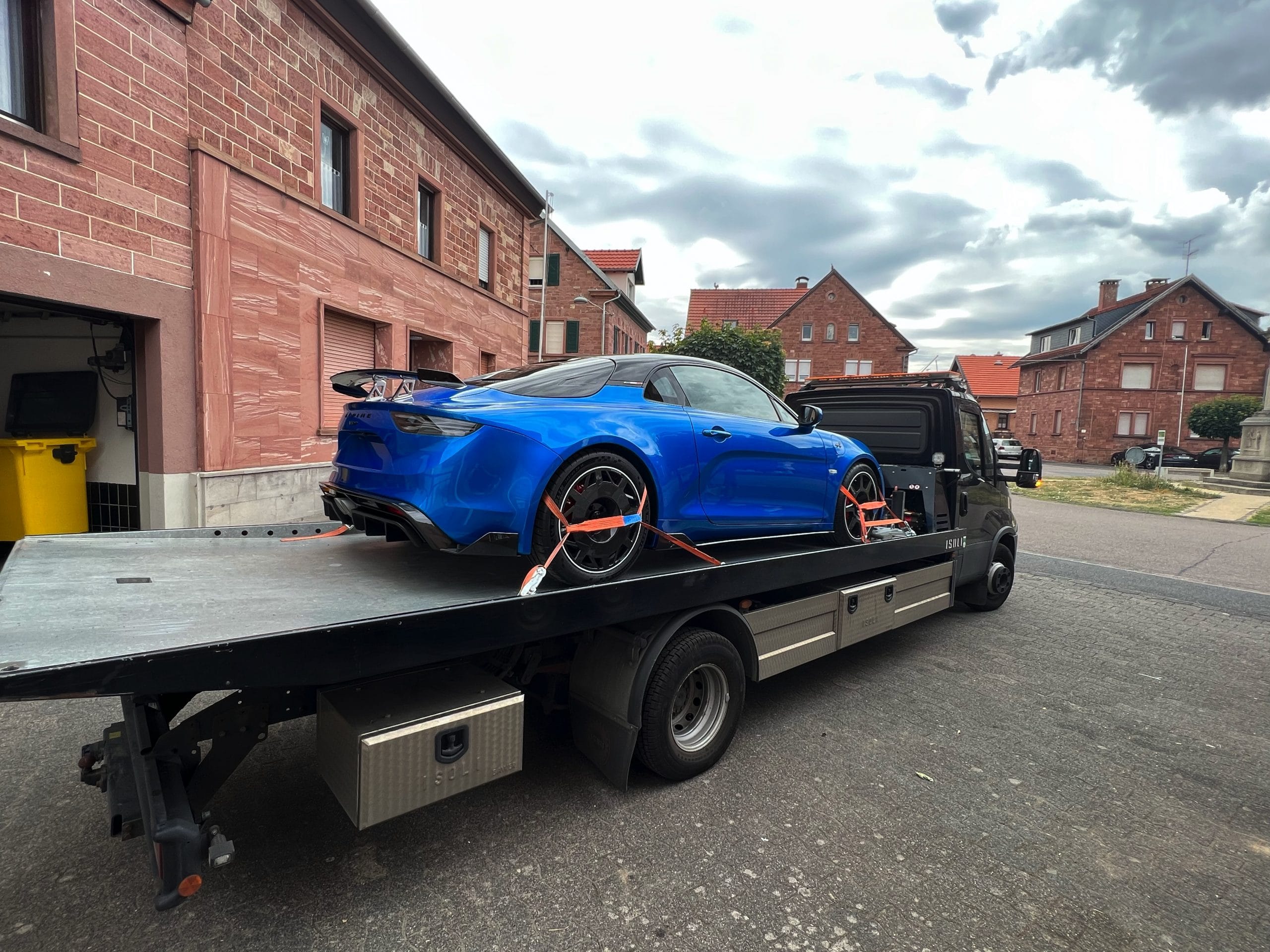 Gesicherter blauer Alpine A110 auf einem offenen Fahrzeugtransporter