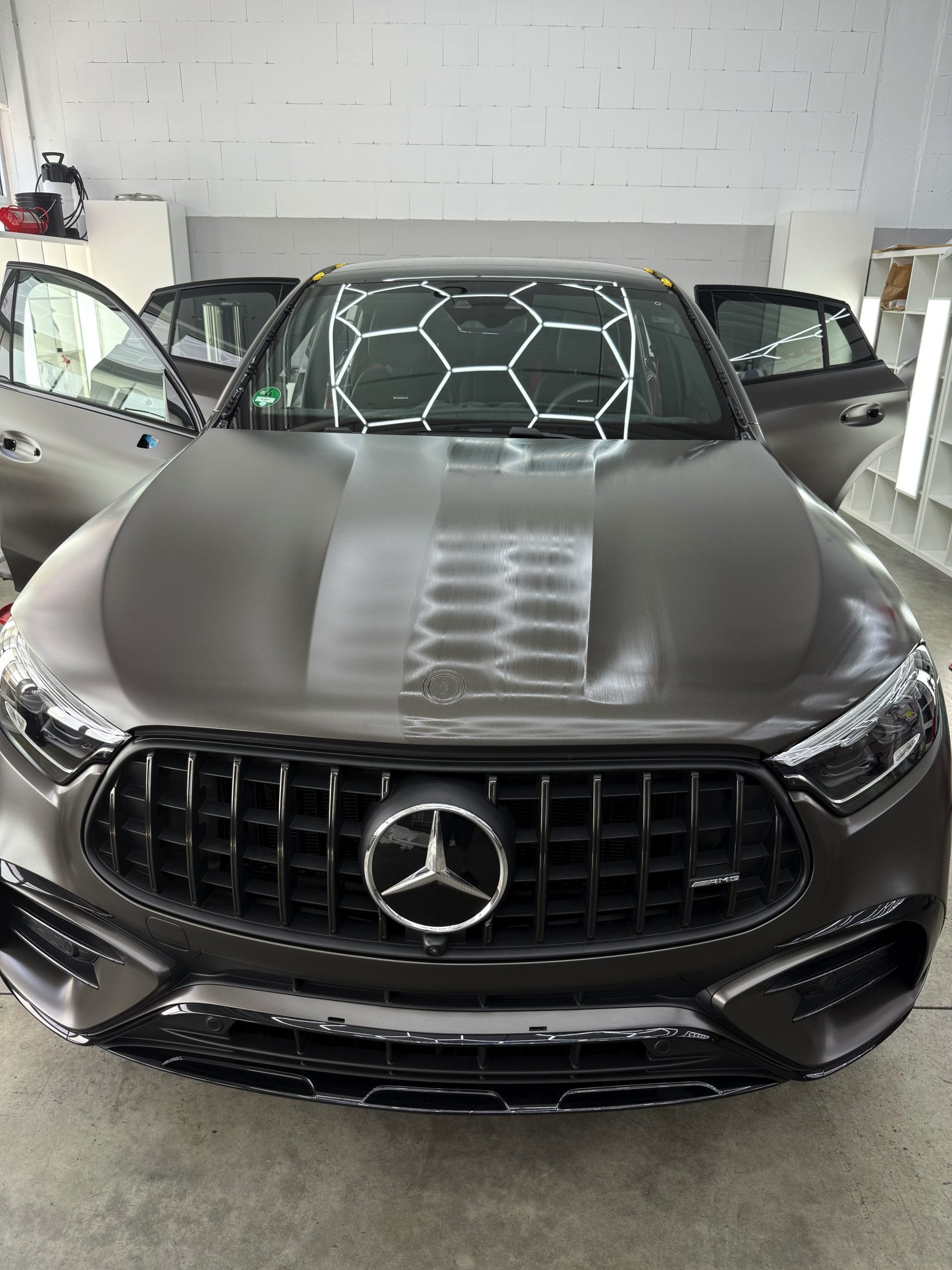 Kontrollierte Verarbeitung einer Versiegelung auf der Motorhaube eines Mercedes-AMG GLE