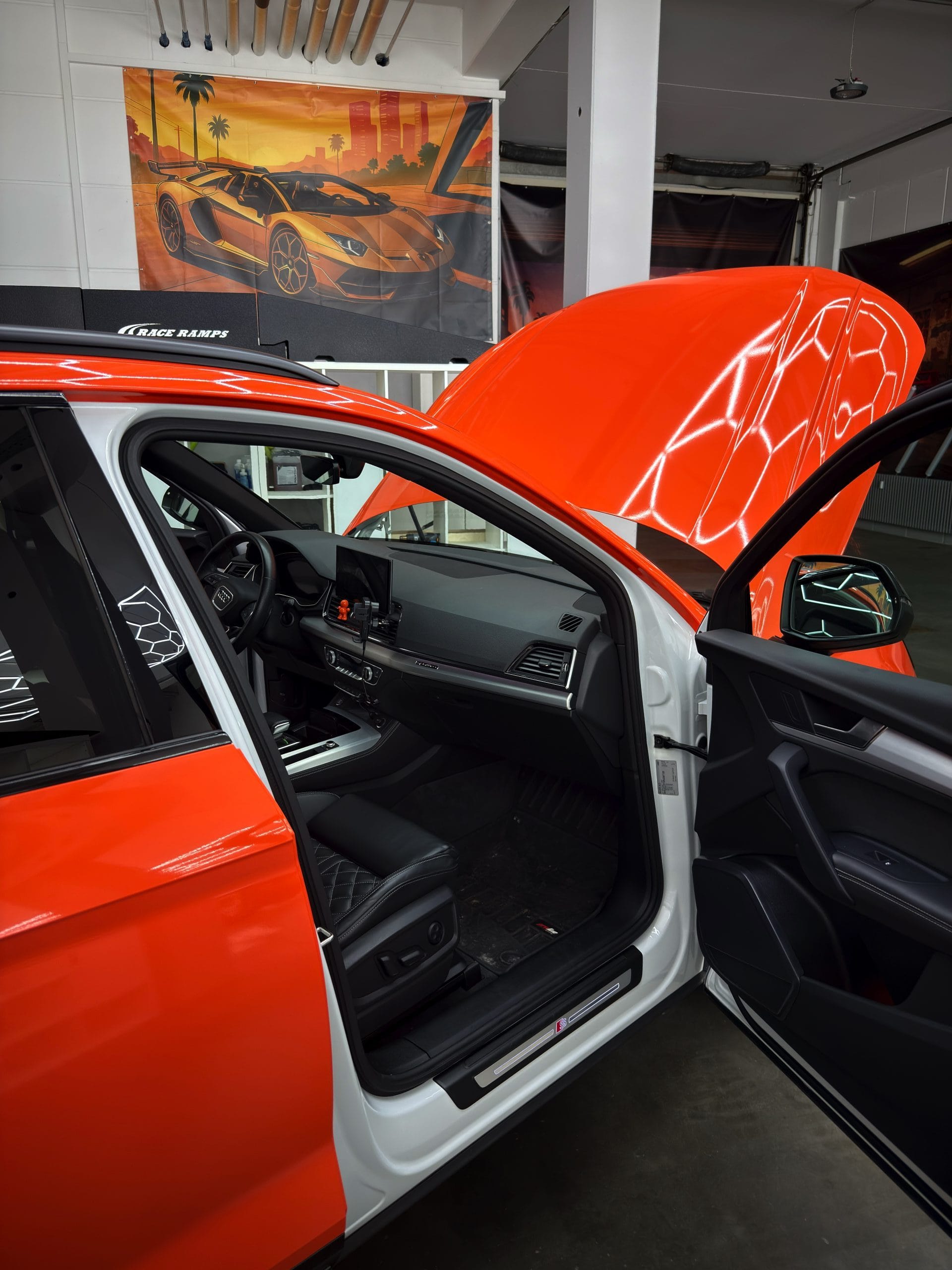 Geöffnete vordere Tür eines weiß lackierten Audi SUV nach orangefarbener Sichtfolierung