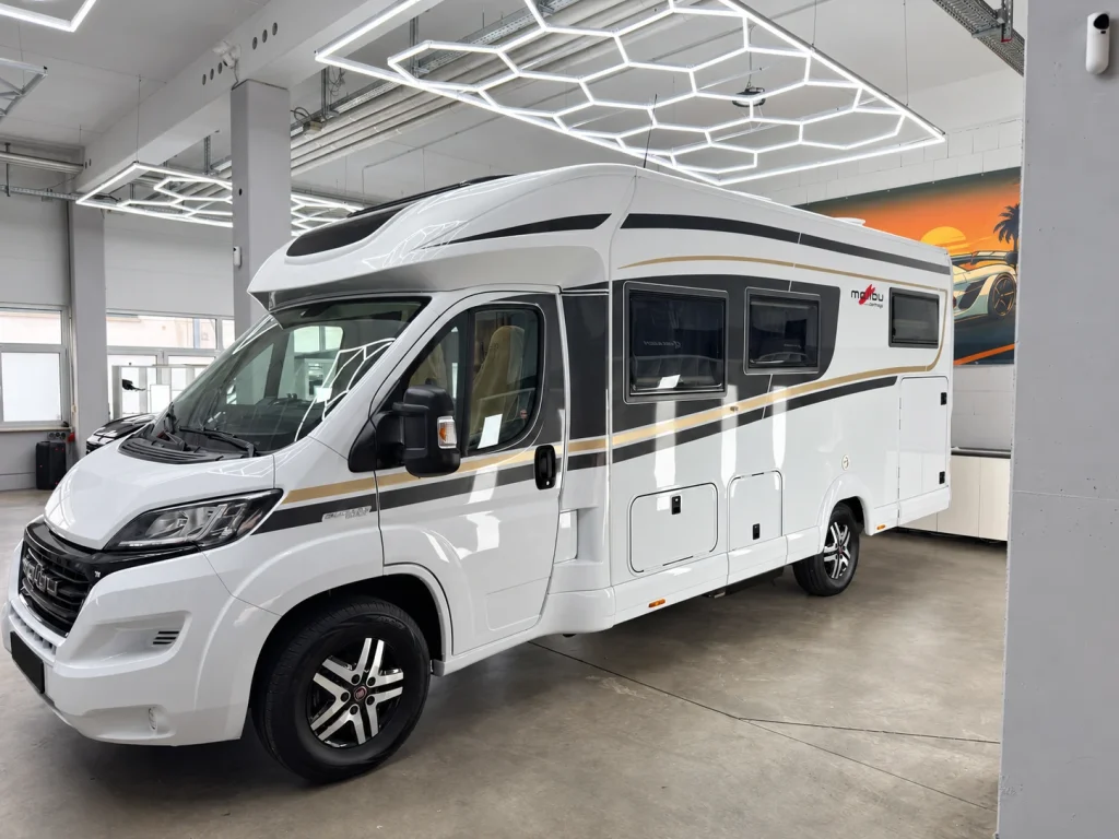 Weißes Wohnmobil in der Werkstatt von WrapIndustries, schräg von vorn links; Kennzeichen unkenntlich.